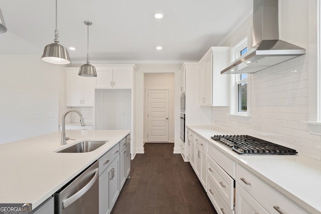 kitchen with wall chimney exhaust hood, white cabinetry, sink, and appliances with stainless steel finishes