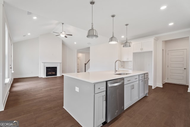 kitchen featuring a kitchen island with sink, sink, stainless steel dishwasher, and decorative light fixtures