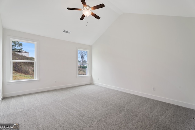 carpeted spare room with vaulted ceiling and ceiling fan