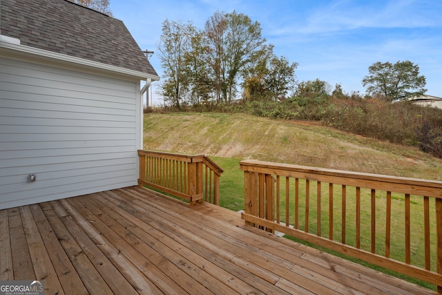 wooden deck featuring a lawn