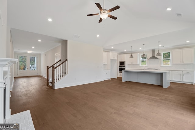 unfurnished living room featuring ceiling fan, light hardwood / wood-style flooring, high vaulted ceiling, and french doors