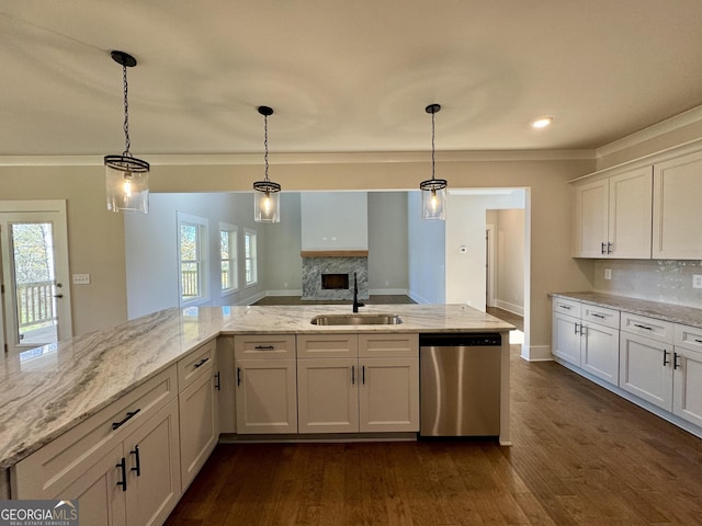 kitchen with stainless steel dishwasher, pendant lighting, white cabinetry, and sink