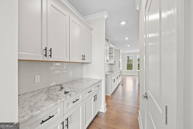 carpeted empty room with a raised ceiling, ceiling fan, and ornamental molding