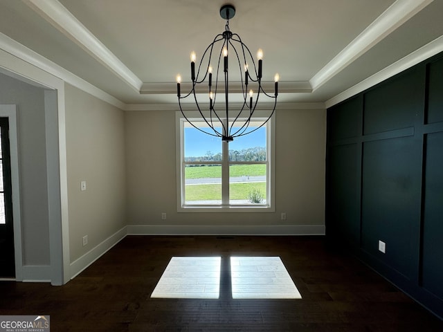 unfurnished dining area featuring a chandelier, a tray ceiling, and crown molding