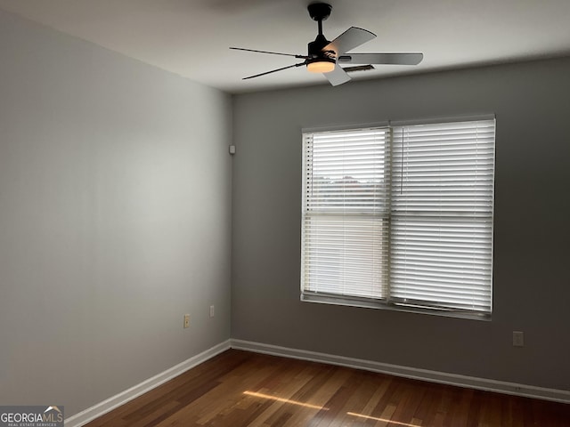 spare room with ceiling fan and dark hardwood / wood-style flooring