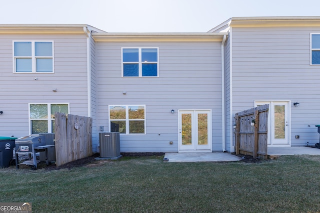 back of property featuring central AC unit and a lawn