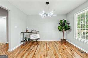 unfurnished dining area featuring wood-type flooring and a notable chandelier