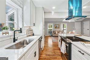 kitchen featuring white cabinets, exhaust hood, sink, and stainless steel electric range