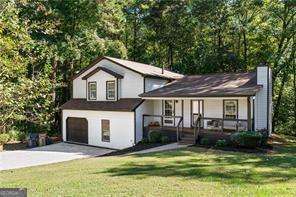 tri-level home with a front lawn, a porch, and a garage