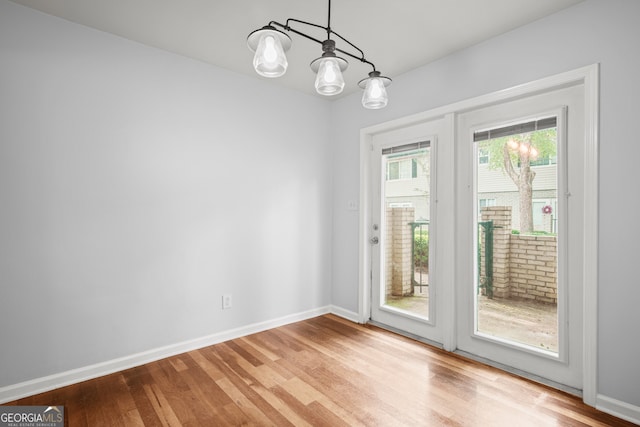 doorway with light hardwood / wood-style flooring and an inviting chandelier