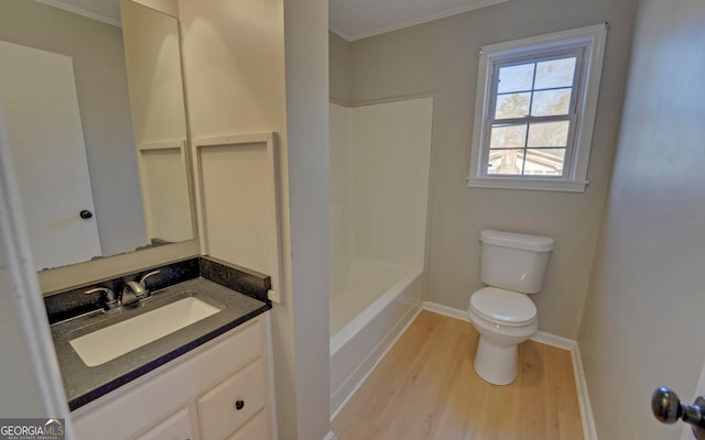 full bathroom with vanity, washtub / shower combination, toilet, ornamental molding, and wood-type flooring