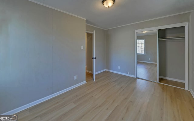 unfurnished bedroom with a closet, ornamental molding, and light wood-type flooring