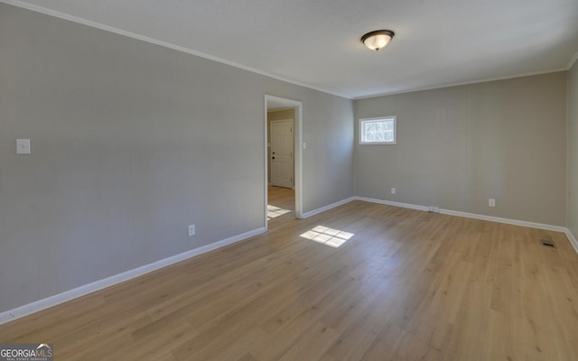 unfurnished room with light wood-type flooring and ornamental molding