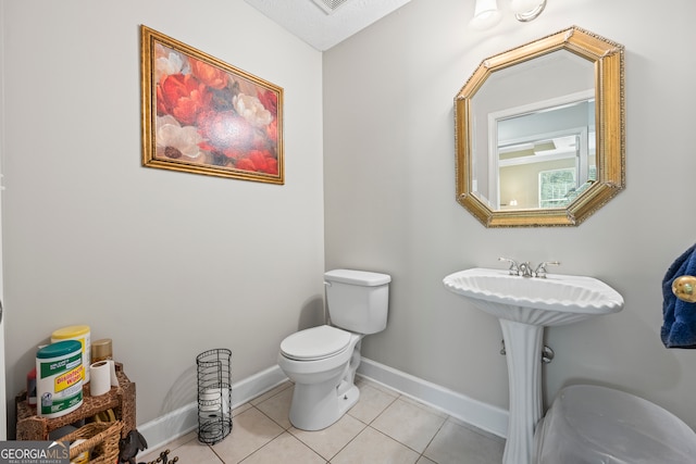 bathroom featuring toilet and tile patterned flooring