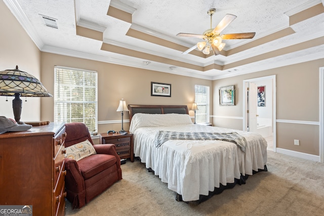 bedroom featuring ornamental molding, a tray ceiling, light carpet, and a textured ceiling