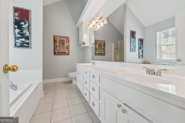 bathroom with tile patterned floors, toilet, vaulted ceiling, vanity, and tiled tub