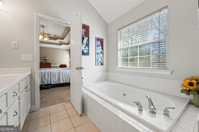 bathroom featuring lofted ceiling, ceiling fan, tile patterned flooring, vanity, and a relaxing tiled tub