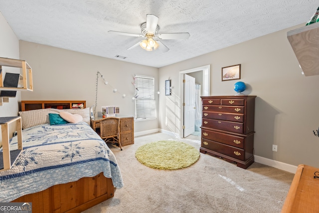 bedroom featuring ceiling fan, light colored carpet, and a textured ceiling