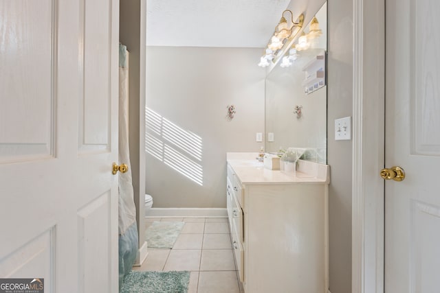 bathroom featuring vanity, tile patterned floors, and toilet