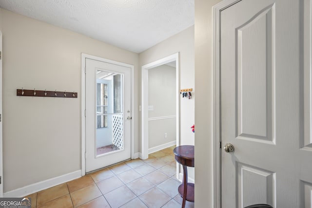 doorway featuring light tile patterned flooring and a textured ceiling