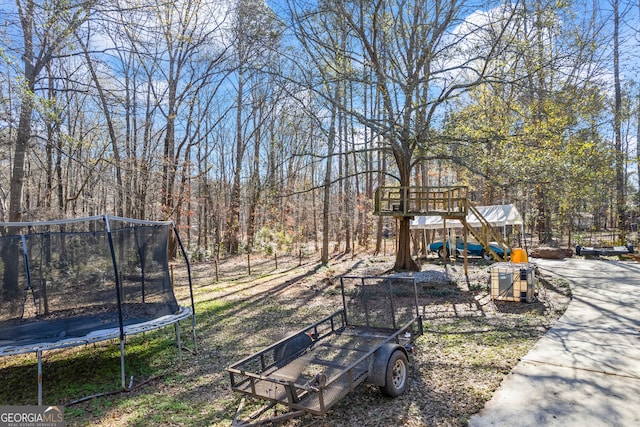 view of yard with a playground and a trampoline