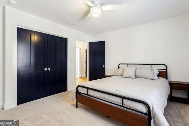 carpeted bedroom featuring ceiling fan and a closet