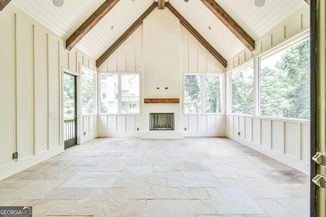 unfurnished sunroom featuring a fireplace and lofted ceiling with beams