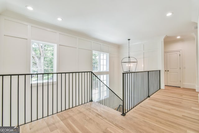 hall featuring plenty of natural light, a notable chandelier, and light hardwood / wood-style flooring