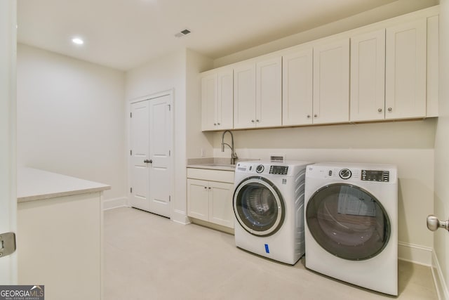 washroom with cabinets, separate washer and dryer, and sink