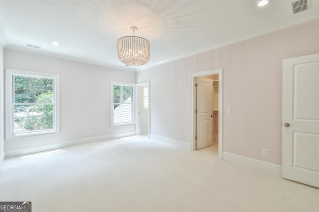 empty room with an inviting chandelier, ornamental molding, and light carpet