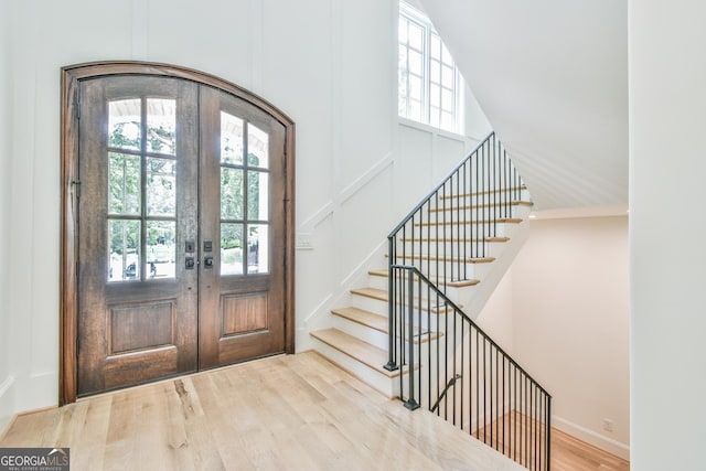 foyer entrance featuring french doors, crown molding, and wood-type flooring