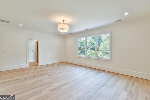 unfurnished room with light hardwood / wood-style floors and crown molding