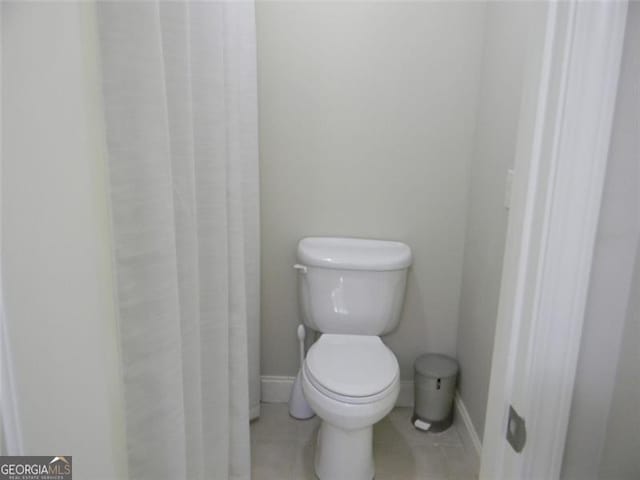 bathroom with toilet and tile patterned flooring