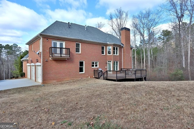 rear view of property featuring a wooden deck, a balcony, a garage, and a lawn