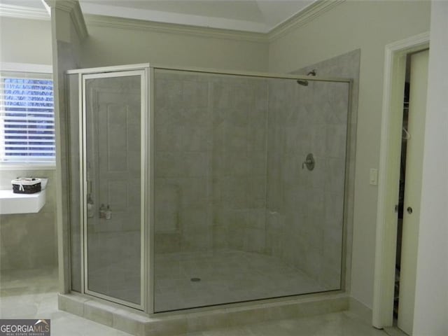 bathroom with ornamental molding and a shower with door