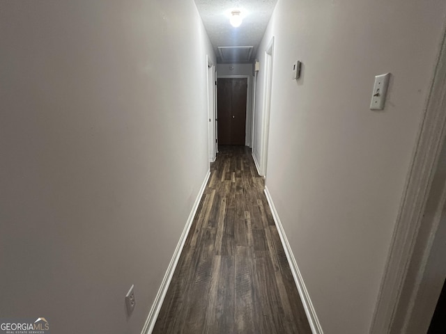 hall with dark hardwood / wood-style floors and a textured ceiling