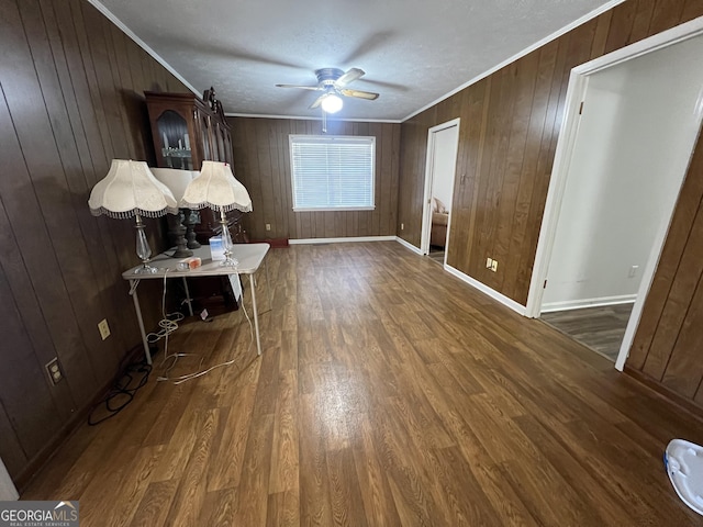 interior space featuring ceiling fan, dark hardwood / wood-style floors, ornamental molding, and a textured ceiling