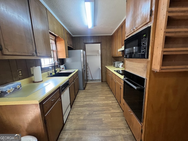 kitchen with black appliances, sink, crown molding, hardwood / wood-style flooring, and a textured ceiling