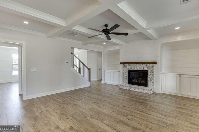 unfurnished living room featuring beamed ceiling, a brick fireplace, and coffered ceiling