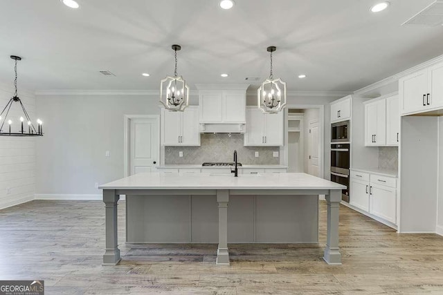 kitchen featuring a large island with sink, a breakfast bar, and hanging light fixtures