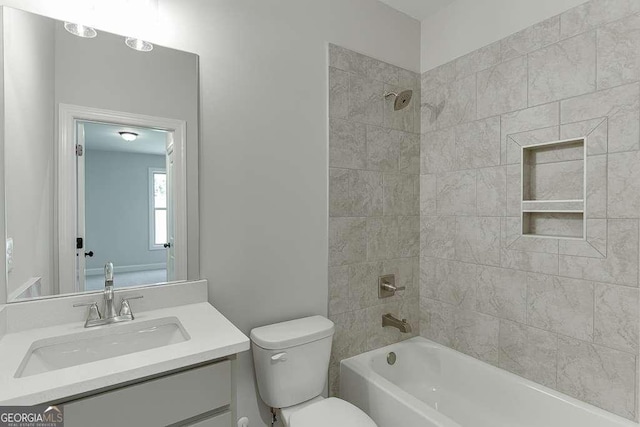 full bathroom featuring toilet, vanity, and tiled shower / bath