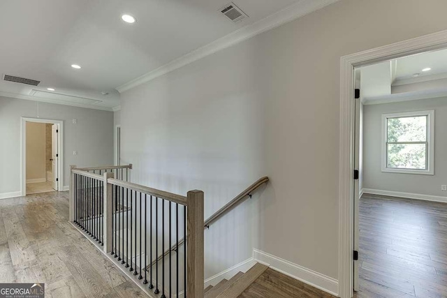 stairs with hardwood / wood-style flooring and ornamental molding