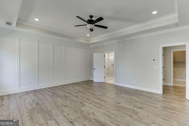 spare room featuring a raised ceiling, ceiling fan, and ornamental molding