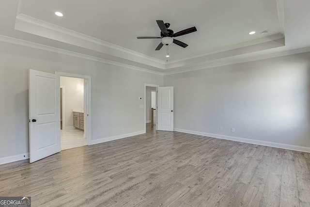 unfurnished room featuring ceiling fan, a raised ceiling, and crown molding