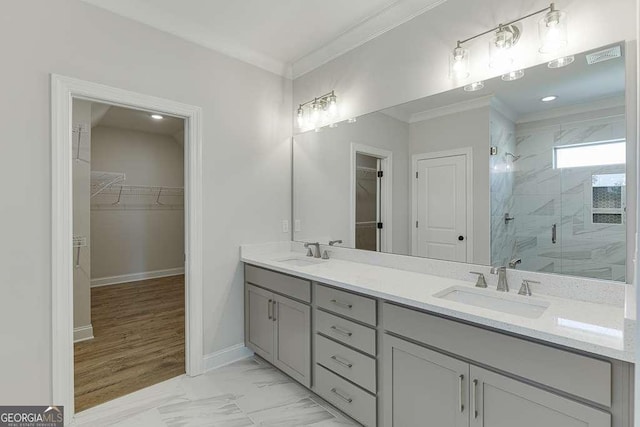 bathroom with a shower with door, vanity, and ornamental molding