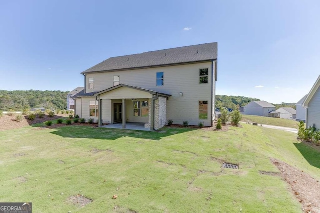 rear view of property with a yard and a patio