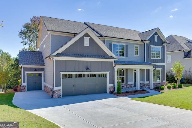 craftsman-style home with a garage, covered porch, and a front yard