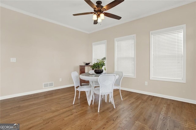 dining area featuring hardwood / wood-style flooring, ceiling fan, and crown molding