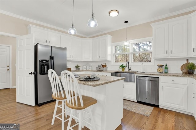 kitchen featuring white cabinets, a kitchen island, and appliances with stainless steel finishes