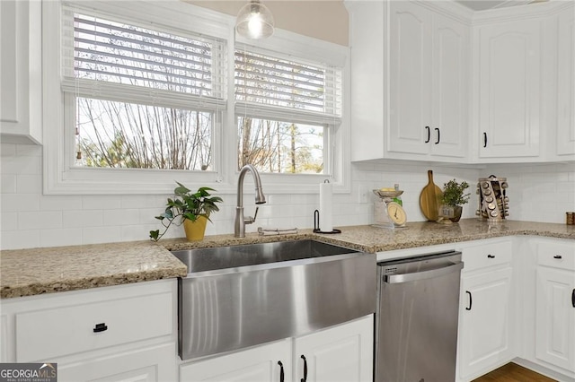 kitchen featuring white cabinets, dishwasher, sink, and backsplash